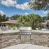 Inviting outdoor space featuring a sleek stainless steel grill, surrounded by lush greenery and comfortable seating, perfect for entertaining.