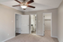 Charming bedroom featuring plush carpet, modern ceiling fan, and access to a walk-in closet and bathroom.