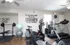 Bright, modern fitness room with exercise bikes, weight bench, and motivational wall quotes.