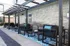Charming outdoor patio with modern seating under a stylish pergola, perfect for relaxation.