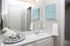 Chic bathroom with a gleaming granite countertop, elegant mirrored tray, and inspirational wall art, exuding a luxurious spa-like ambiance.