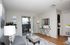 Elegant living room with modern decor, featuring a cozy grey sofa, stylish patterned ottoman, and sleek glass door leading to a balcony. Perfect for relaxation and entertaining.