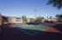 Inviting tennis court surrounded by modern apartment buildings and lush greenery, perfect for active and leisurely lifestyles.