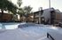 Inviting residential community with a serene swimming pool surrounded by lush greenery and stylish outdoor seating.