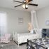 Charming bedroom with elegant white bedframe, soft canopy, and cozy decor, perfect for a relaxing and dreamy atmosphere.