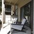 Charming apartment patio featuring modern, cushioned lounge chairs, perfect for relaxing in a cozy outdoor space.