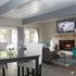 Inviting living room with elegant dining area, cozy fireplace, and natural light streaming through large French doors.