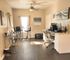 Bright, modern workspace with stylish art decor, featuring high stools by a window and chic office chairs.