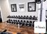 Elegant fitness area at The Veranda with mirrored walls and a variety of dumbbells on a sleek rack.