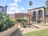 Charming apartment courtyard with a cozy pergola, lush greenery, and elegant archways leading to upper-level residences.