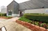 Charming apartment entrance with manicured landscaping, modern architecture, and inviting pathway.