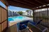 Inviting poolside view at a modern apartment complex with comfortable lounge chairs under a stylish pergola, perfect for relaxation.