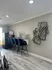 Modern apartment corner with sleek bar stools, geometric wall art, and elegant decor under natural lighting.