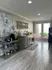 Bright and welcoming kitchen space with modern decor, featuring sleek cabinetry, elegant artwork, and natural light from expansive windows.
