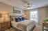Inviting bedroom with plush carpeting, elegant decor, and ample natural light, featuring a comfortable bed and stylish accents.