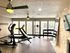 Bright and modern fitness center with state-of-the-art equipment, large windows for natural light, and vibrant ambiance.
