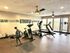 Bright and modern fitness room featuring a range of exercise equipment including treadmills, stationary bike, rowing machine, and inspiring wall mural.