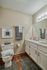 Inviting bathroom featuring elegant vanity, polished countertops, and plush towels on a warm wooden floor.
