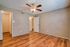 Inviting room with warm wood flooring, ample closet space, and a ceiling fan, offering comfort and style.