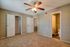 Inviting bedroom with plush carpet, ceiling fan, and convenient ensuite bathroom, ideal for comfort and relaxation.