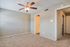 Bright and spacious bedroom with plush carpeting, modern ceiling fan, and neutral wall tones.