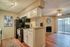 Inviting open-plan kitchen and living area with modern cabinets, warm wood flooring, fireplace, and ample natural light from sliding glass doors.