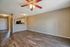 Spacious apartment living area with elegant wood flooring and a ceiling fan, offering a bright and inviting space near the kitchen.