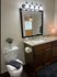Elegant bathroom featuring a granite countertop, stylish dark wood cabinetry, and ambient lighting for a cozy touch.