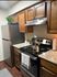 Charming kitchen with modern stainless steel appliances, elegant granite countertops, and rich wood cabinetry.