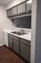 Modern kitchen with sleek cabinetry, double sink, and elegant wood flooring.