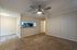 Inviting living area with stylish ceiling fan, plush carpet, and modern pass-through to the kitchen.