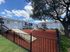 Charming apartment complex with modern amenities, featuring a spacious red mulch play area under a clear blue sky.