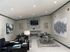 Modern living room with sleek office setup, elegant dining area, stylish fireplace, and contemporary art on neutral walls.