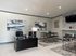Modern office space with elegant decor, featuring sleek black desk, stylish wall art, and contemporary furniture.