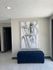 Chic hallway with modern abstract art and elegant blue tufted bench, featuring contemporary tile flooring.