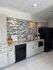 Modern kitchen with sleek grey cabinetry, elegant mosaic tile backsplash, and stainless steel appliances. Bright, inviting space perfect for contemporary living.