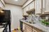 Modern kitchen with stylish backsplash, granite countertops, and black appliances. Bright and inviting with elegant cabinetry and contemporary fixtures.