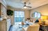 Inviting living room with elegant decor, featuring a cozy beige sofa, stylish modern coffee table, and vibrant wall art, illuminated by natural light through large sliding doors.