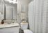 Cozy bathroom with elegant granite countertop, modern fixtures, and patterned shower curtain, exuding a contemporary charm.