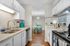 Charming modern kitchen with sleek countertops, stainless steel appliances, and elegant dining area in the background, ideal for contemporary living.