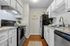 Modern kitchen with sleek granite countertops, stainless steel appliances, and white cabinetry, featuring a cozy wooden floor and stylish decor accents.