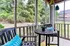 Charming screened patio with stylish seating, vibrant cushions, and a scenic view of lush greenery.