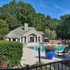 Charming poolside retreat with lush greenery, inviting lounge chairs, and vibrant blue planters in serene suburban setting.