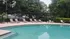 Inviting swimming pool area with stylish loungers and lush greenery, ideal for relaxation and outdoor enjoyment.
