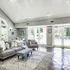 Bright and inviting living room with modern decor, plush seating, and large windows offering a serene garden view.