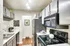 Modern kitchen with sleek appliances and stylish cabinetry, featuring elegant lighting and hardwood flooring.
