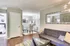 Modern living area with chic decor, featuring a plush sofa, stylish coffee table, and a cozy dining nook with patterned chairs set on wooden flooring.