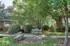 Serene apartment courtyard surrounded by lush greenery and shaded benches.