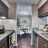 Elegant kitchen with sleek countertops and stainless steel appliances leading into a cozy dining area with a stylish table set and modern decor.