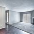 Inviting living room with elegant hardwood floors, plush carpeting, and abundant natural light from large sliding glass doors.